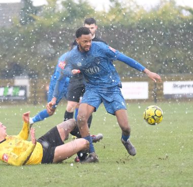 walthamstow's rasheed salau holds off a mildenhall defender